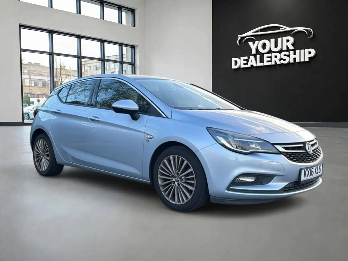 Finished image of a silver hatchback in a bright showroom with the dealer logo on the wall behind