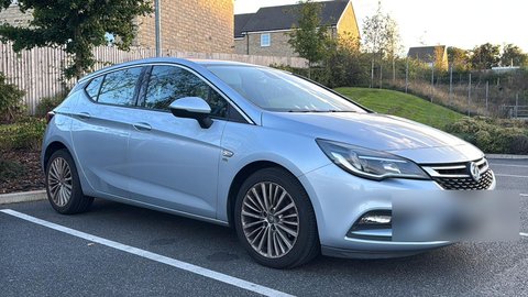 Before: front three-quarter phone photo of a silver hatchback outdoors