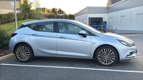 Before: side-profile phone photo of a silver hatchback in a car park